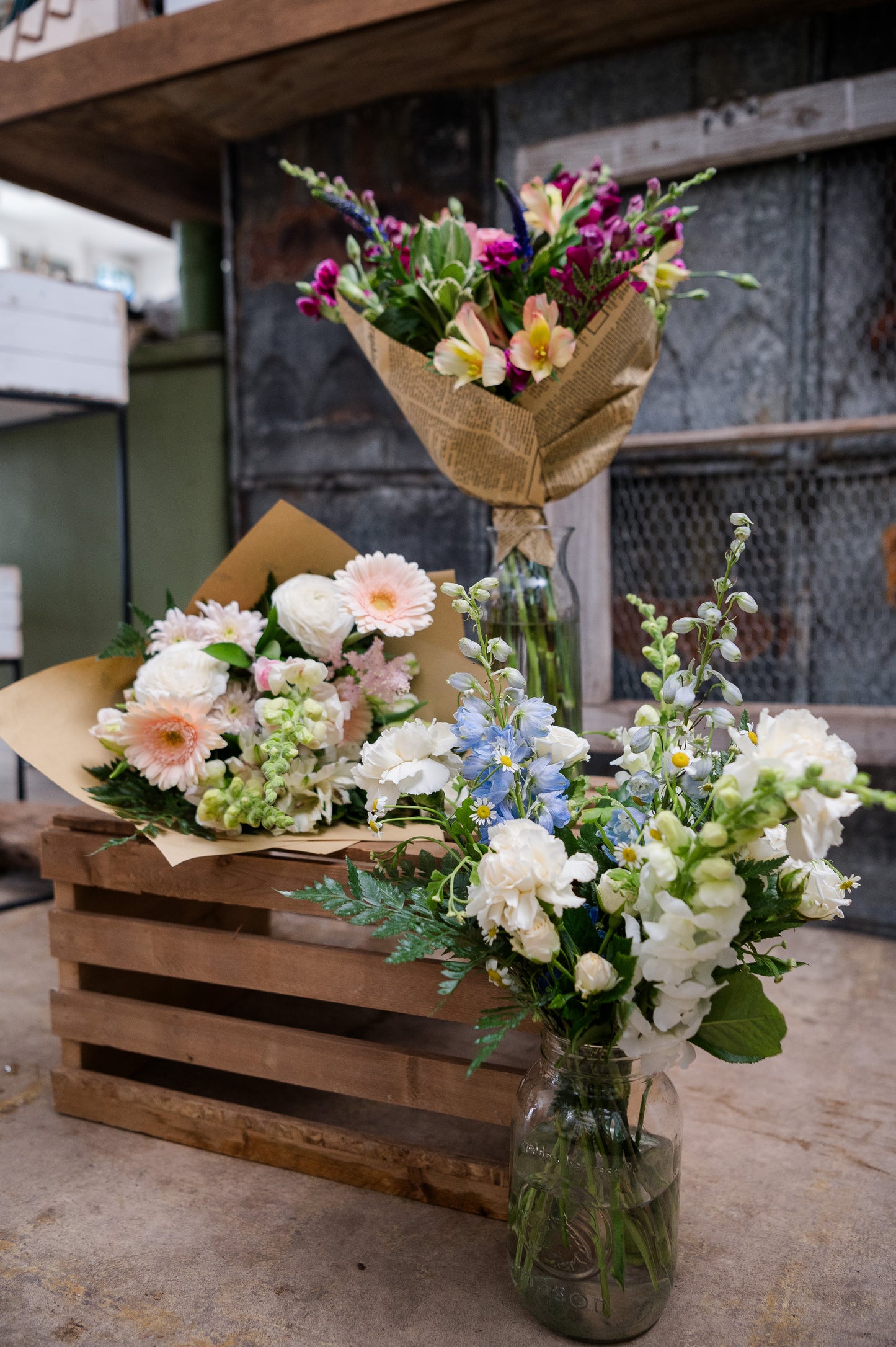 Bouquets of flowers on a wooden crate with a rustic background. For Mother's Day Flower Delivery
