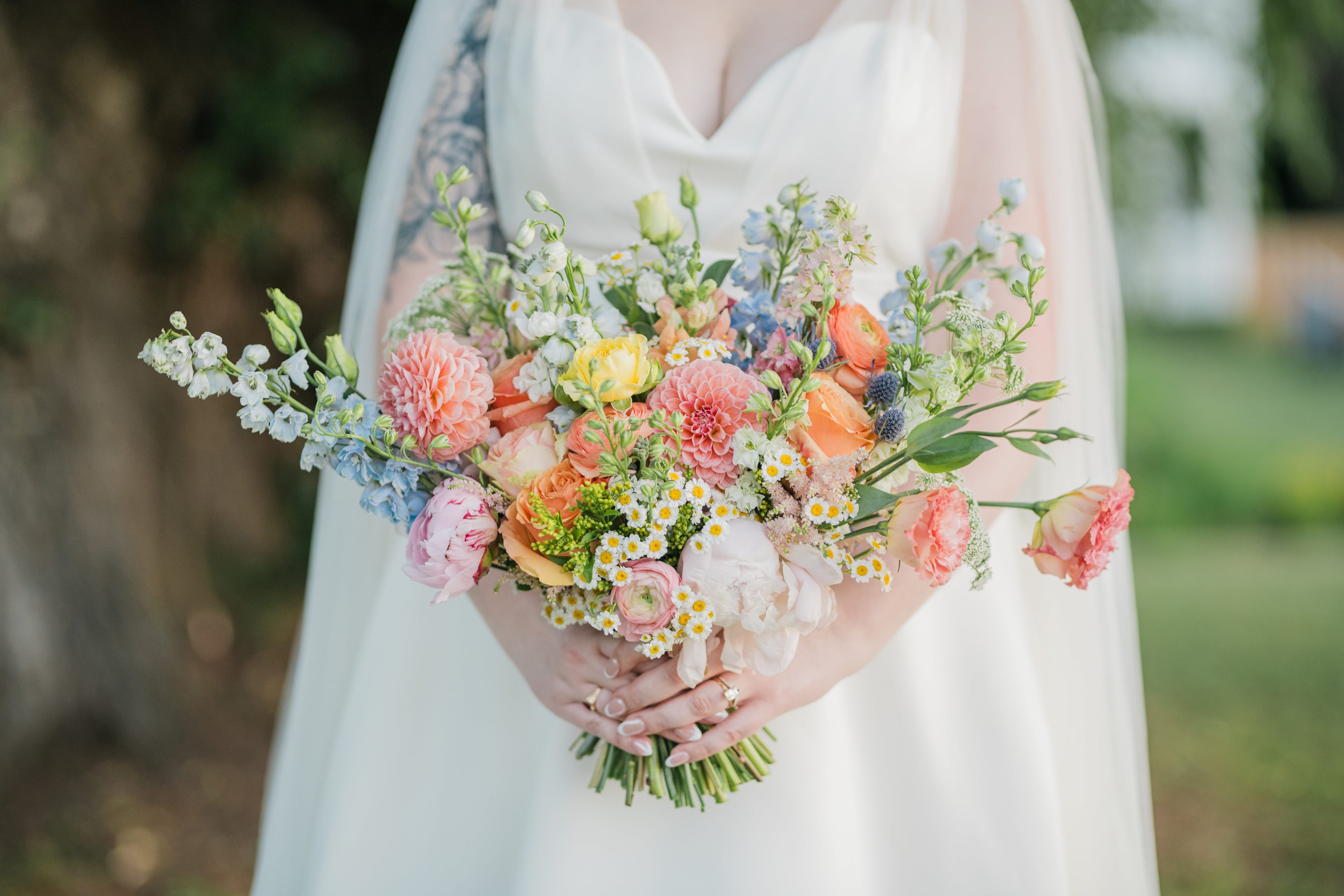 Garden-style bridal bouquet with colourful blooms and greenery by The Green House Floral Bar.